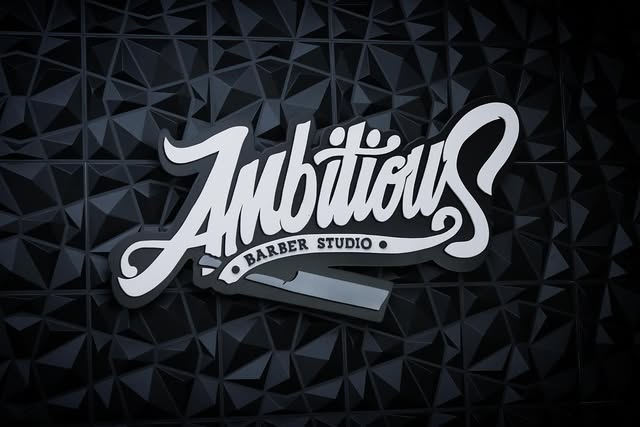 Ambitious Barber Studio logo sign on the studio wall